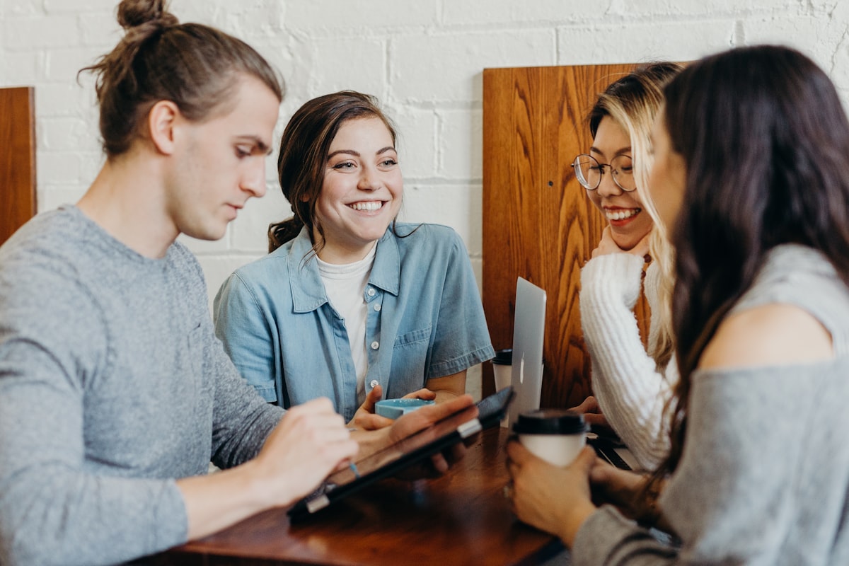 Young people talking and laughing together around a table